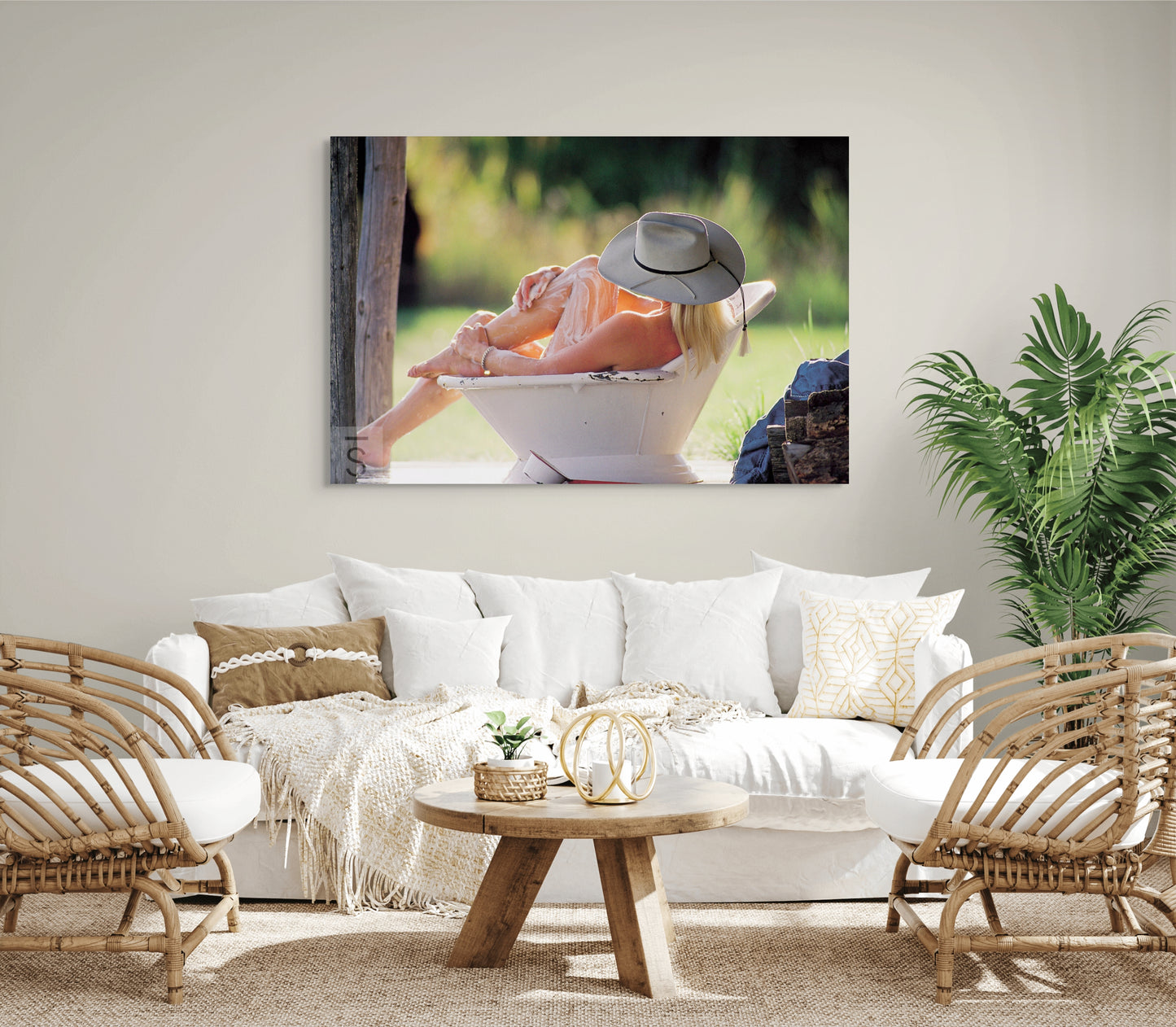 a cowgirl photograph over a couch in a living room.